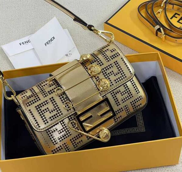 Iconic, boxy mini Baguette bag from the Versace by Fendi collection. Made of gold-coloured leather with FF motif gold laser-cut perforations that create an effect that evokes the Versace metal mesh.