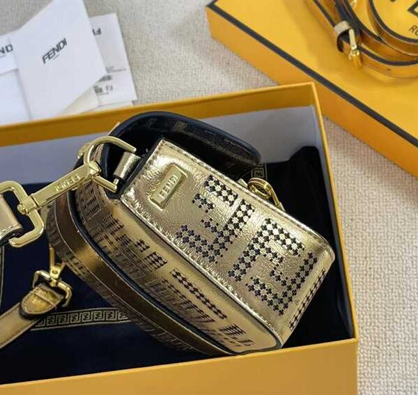 Iconic, boxy mini Baguette bag from the Versace by Fendi collection. Made of gold-coloured leather with FF motif gold laser-cut perforations that create an effect that evokes the Versace metal mesh.